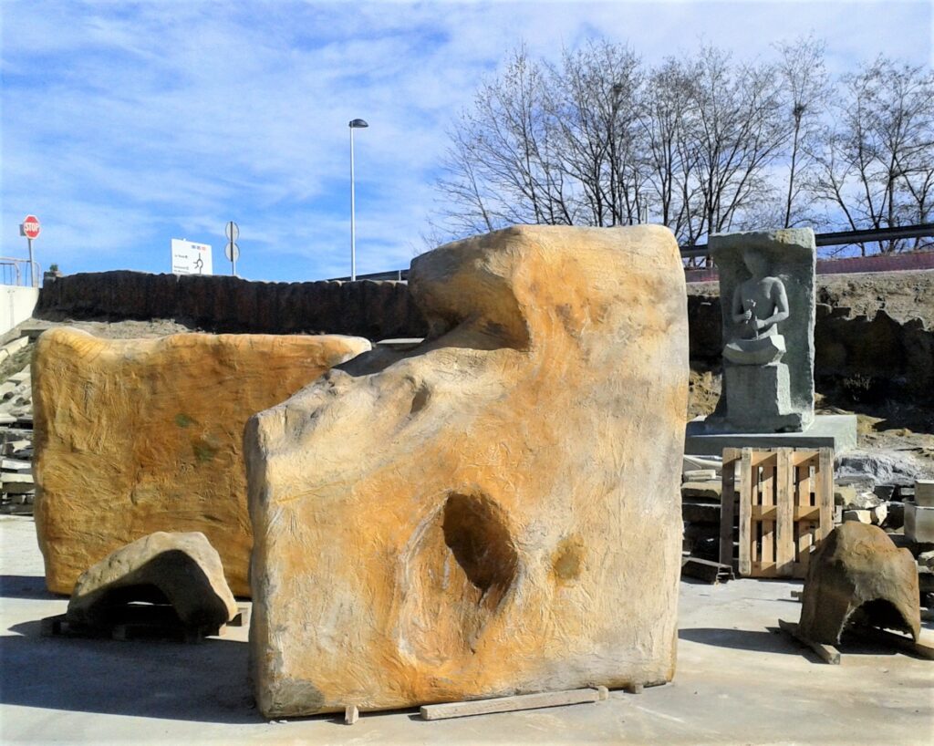 Estructuras de roca artificial y esculturas en piedra en un taller de modelado y tematización de espacios exteriores.